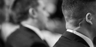 Person in suit wearing an earpiece, blurred background.