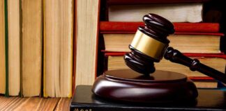 Gavel resting on books in front of bookshelf.