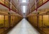 Long hallway with prison cells on both sides.