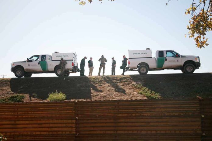 Border patrol agents near vehicles on embankment daytime