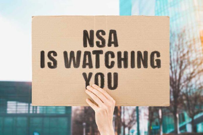 hand holding a cardboard sign that reads NSA is watching you