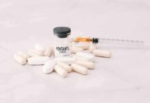 Vial labeled fentanyl surrounded by pills and syringe