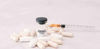 Vial labeled fentanyl surrounded by pills and syringe