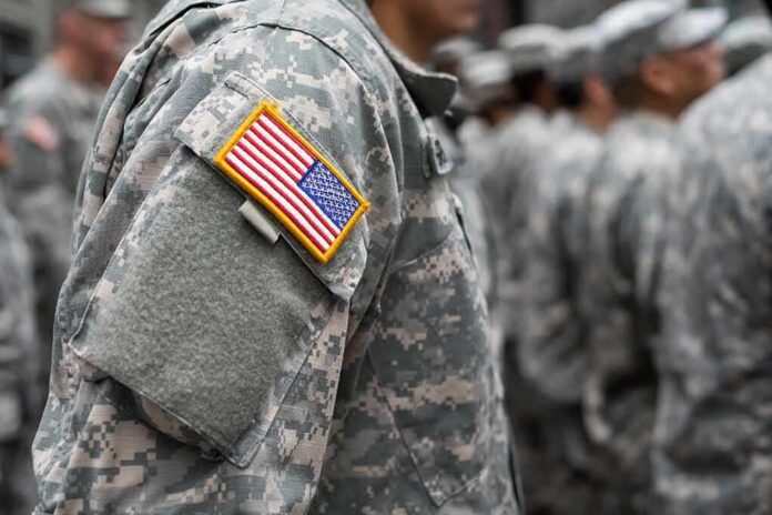 People in camouflage uniforms with US flag patch