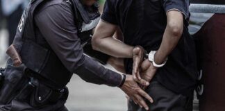 Police officer arresting a person with handcuffs