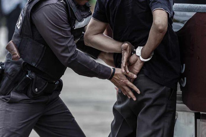Police officer arresting a person with handcuffs