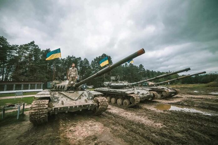 Tanks with flags and soldier on muddy ground