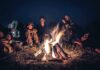 People sitting around a campfire at night