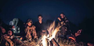 People sitting around a campfire at night