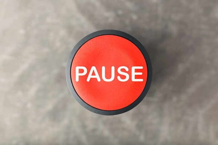 Red button labeled pause on gray background