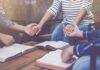Group holding hands over open books