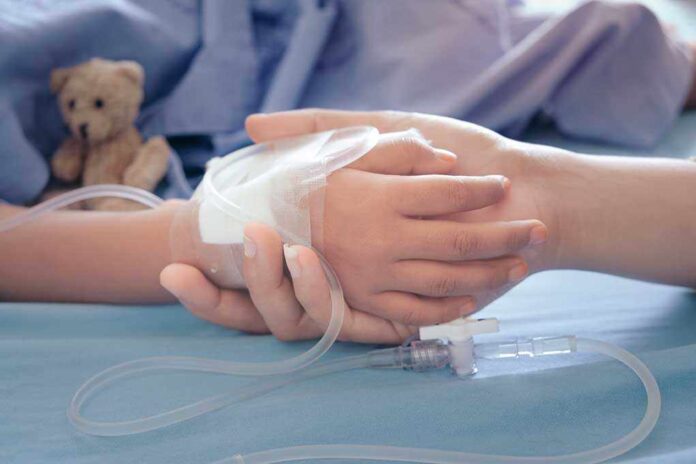 Childs hand with IV held by adult