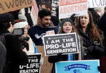 Group holding prolife and antiabortion signs at rally