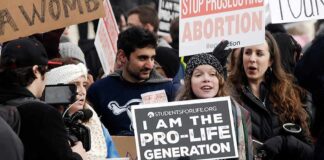 Group holding prolife and antiabortion signs at rally