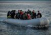 People on a packed raft in open water.