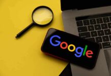 Magnifying glass laptop and smartphone displaying Google logo