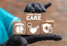 Gloved hand holding longterm care wooden blocks
