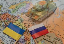 Toy tank on map with Ukraine and Russia flags