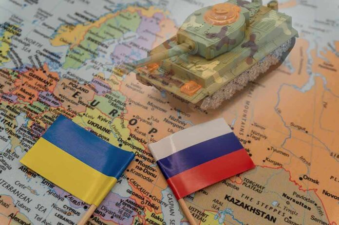 Toy tank on map with Ukraine and Russia flags
