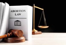 Gavel and abortion law book next to scales