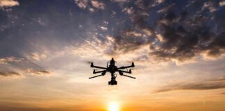 Drone flying against sunset sky.