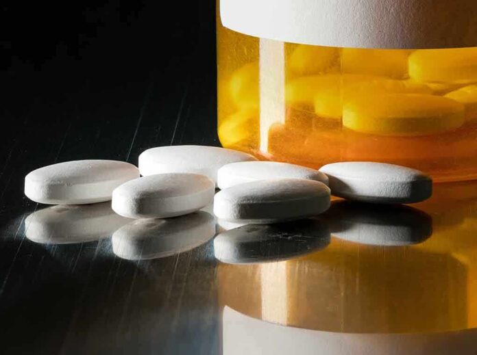 White pills beside an orange pill bottle