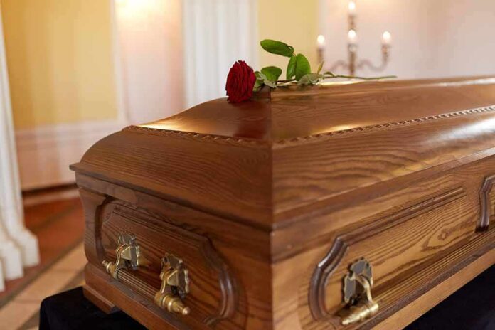 Wooden coffin with red rose on top