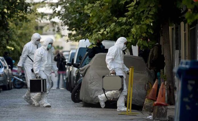 Investigators in hazmat suits carrying equipment cases