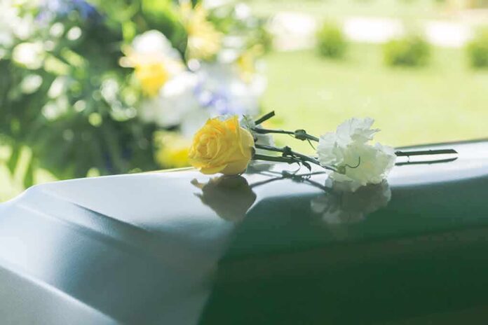 Two flowers on a casket at a funeral