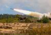 Military tank firing a missile in forest area