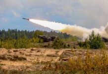 Military tank firing a missile in forest area