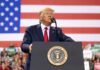Man speaks at podium with U.S. flag background
