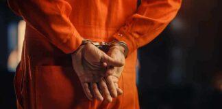 Person in orange jumpsuit with handcuffs behind back