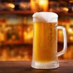 Mug of beer on wooden table in bar