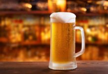 Mug of beer on wooden table in bar