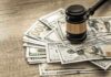 Gavel on a pile of hundred-dollar bills