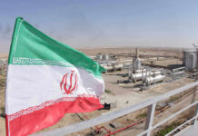 Iranian flag near an industrial gas refinery