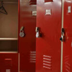 Red lockers with padlocks, one open with hanger