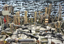 Room filled with various firearms and ammunition belts