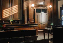 Empty courtroom with wooden interior and green lamps
