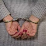 Person in handcuffs with gray sweater