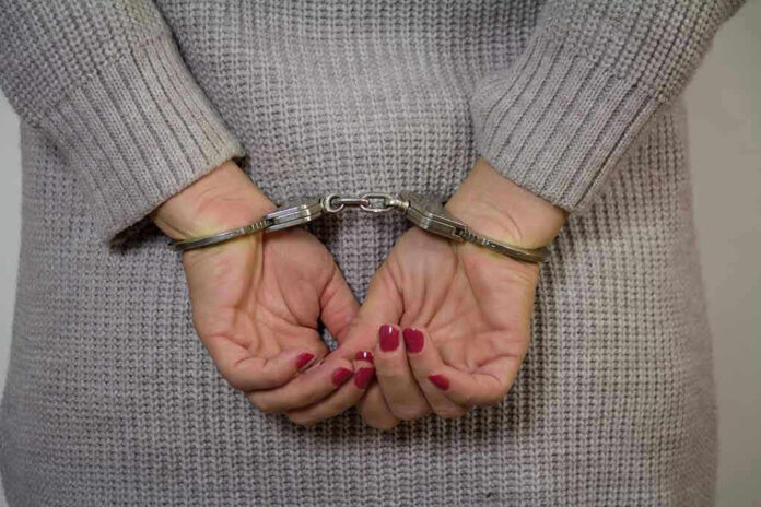 Person in handcuffs with gray sweater