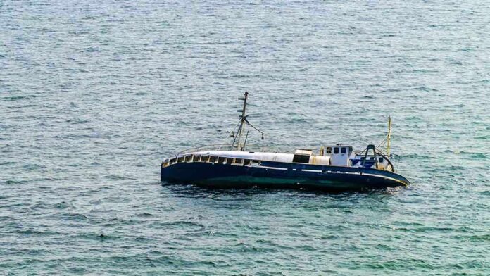 An abandoned boat floating on the ocean surface