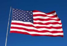 Waving American flag against a clear blue sky
