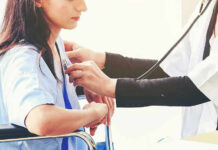 Doctor examining patient with stethoscope in hospital
