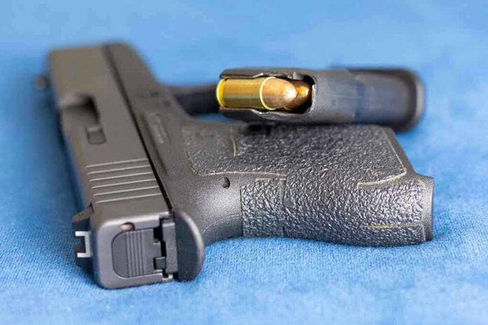 Handgun on blue fabric with visible bullet cartridge