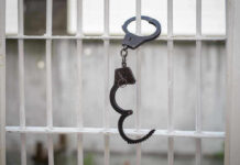 Handcuffs hanging on a barred window
