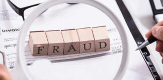 Fraud blocks under magnifying glass on invoices.