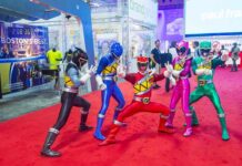 Five costumed characters posing at a convention event