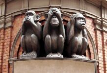 Three monkey sculptures representing see no evil, hear no evil, and speak no evil